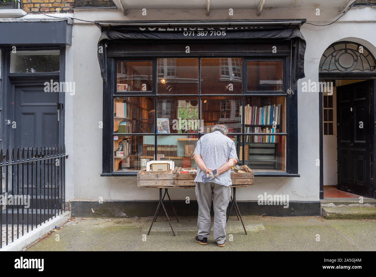 Man outside Collinge & Clark secondhand bookshop, Leigh Street, London Stock Photo