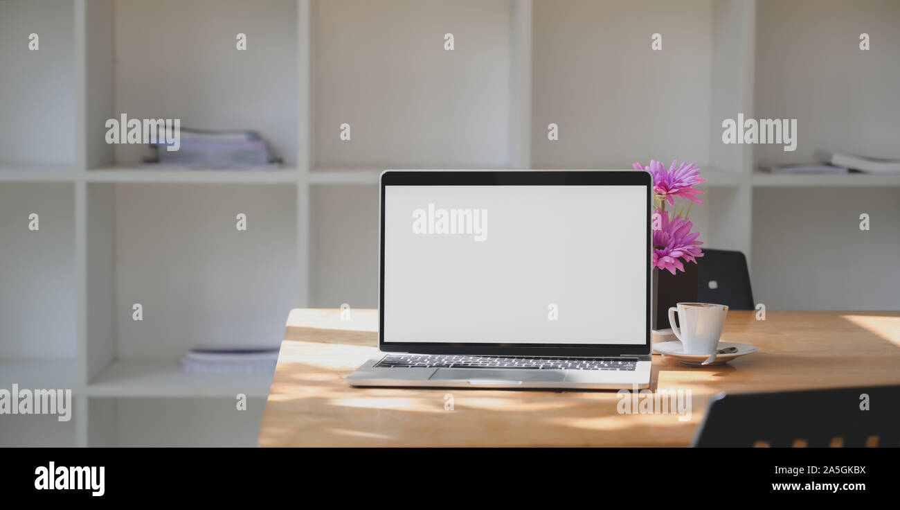 Open blank screen laptop computer in comfortable workspace with pink ...