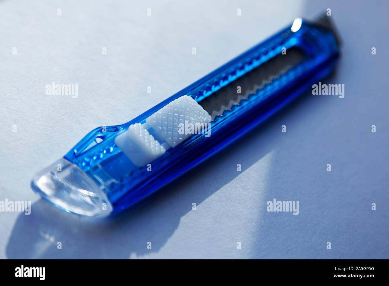 a blue carpet knife in close-up on light surface Stock Photo