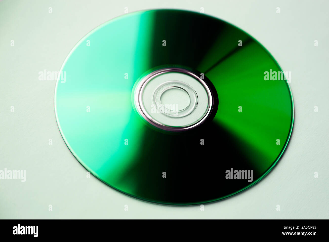 a dvd disc that looks green in the sunlight from windows is on white ...