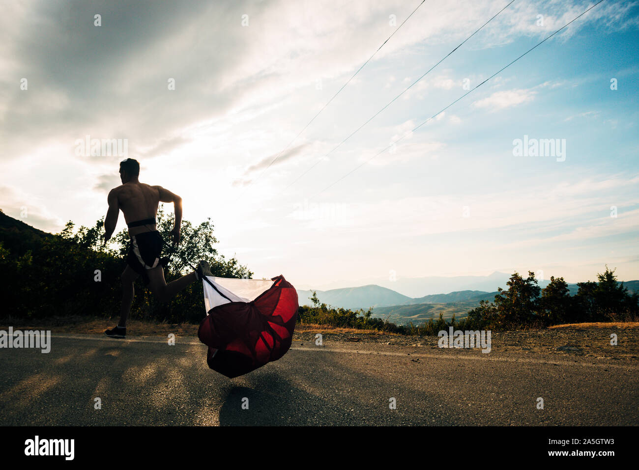 Athletic fit young sport fitness model in his twenties in full body length on road outside in city urban Stock Photo