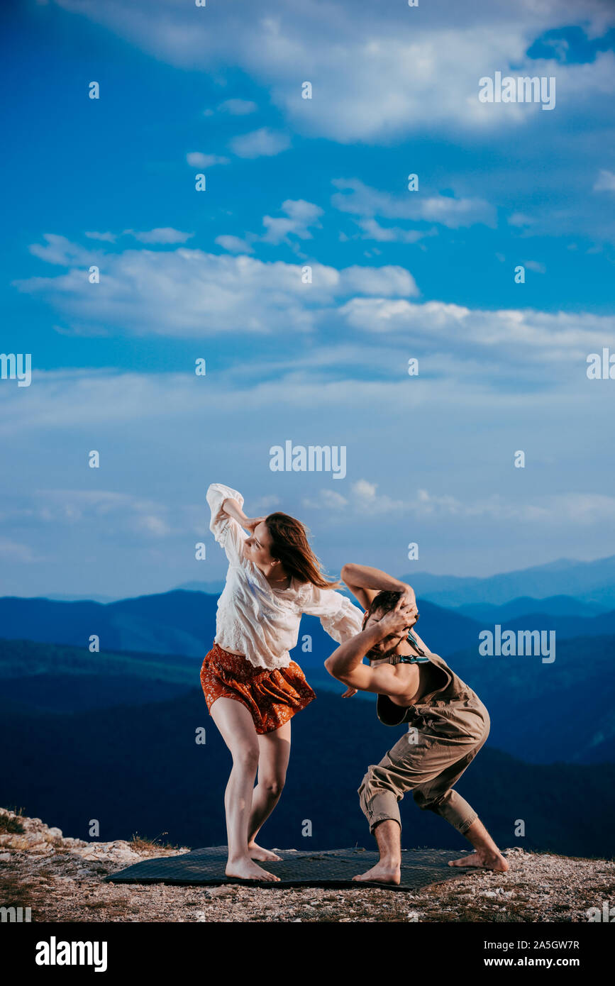 Two athletic young dancers making a performance at mountain peak Stock Photo