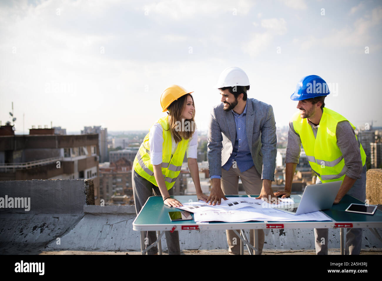 Architects team and engineers looking paper plans at construction site. Stock Photo