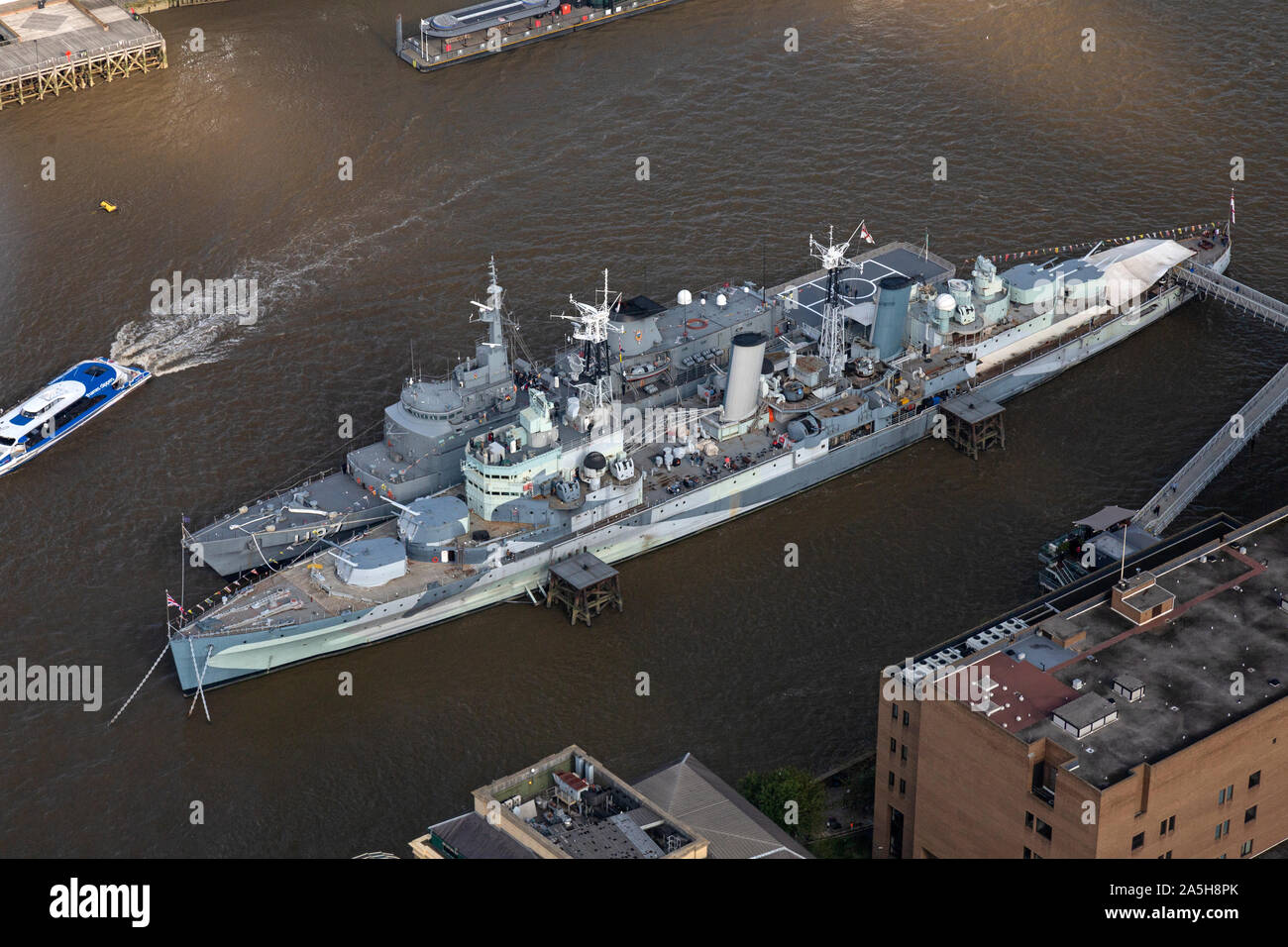 An aerial view looking down on the River Thames in London, with HMS Belfast and a Brazilian Navy training Ship U27 moored alongside. Stock Photo