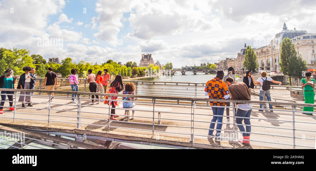 young people on Léopold-Sédar-Senghor footbridge with louvre and musee d´orsay in background Stock Photo