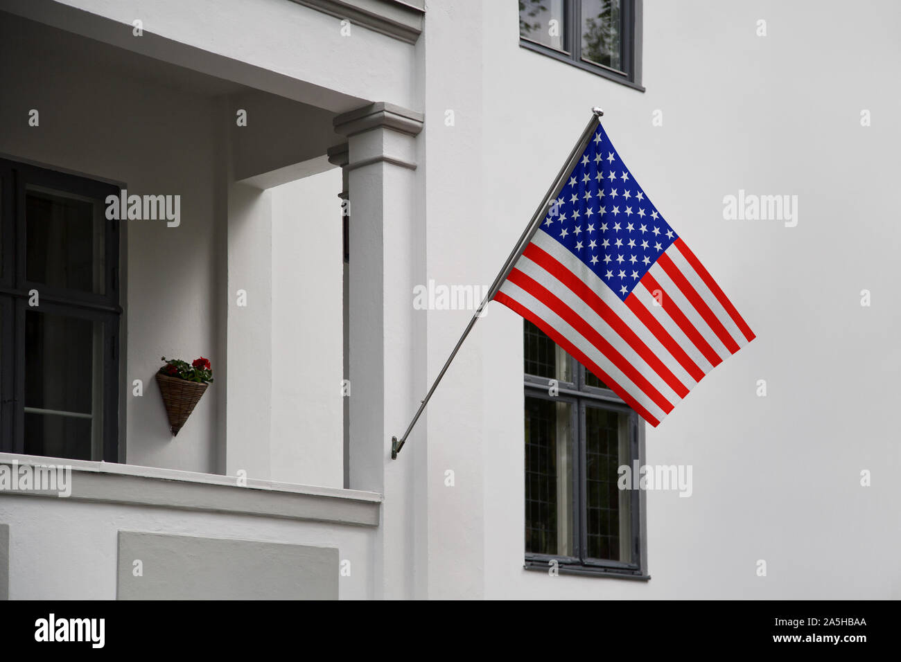 USA flag. American flag displaying on a pole in front of the house. National flag of United States of America waving on a home hanging from a pole on Stock Photo