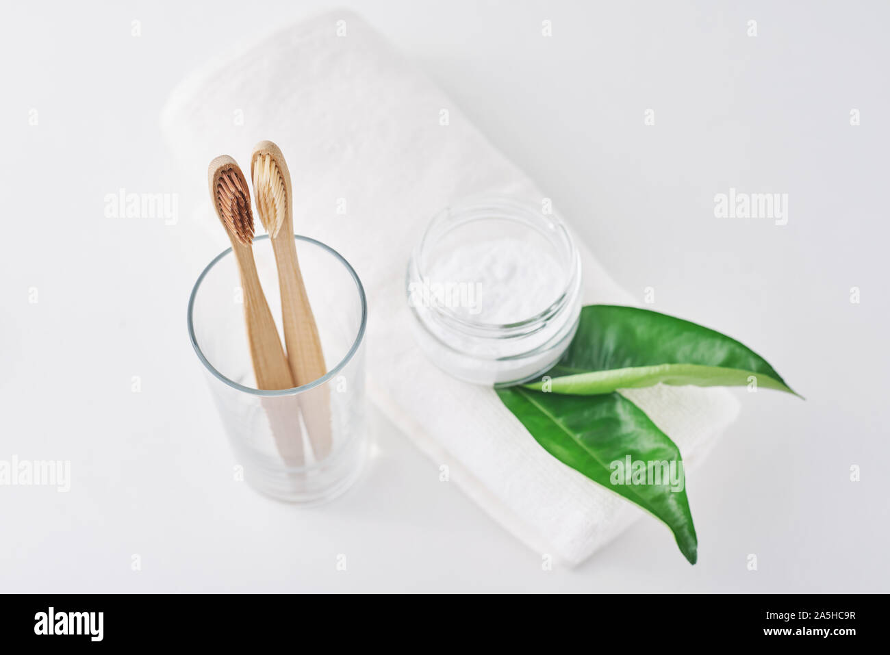 Two wooden bamboo eco friendly toothbrushes in glass, baking soda and ...
