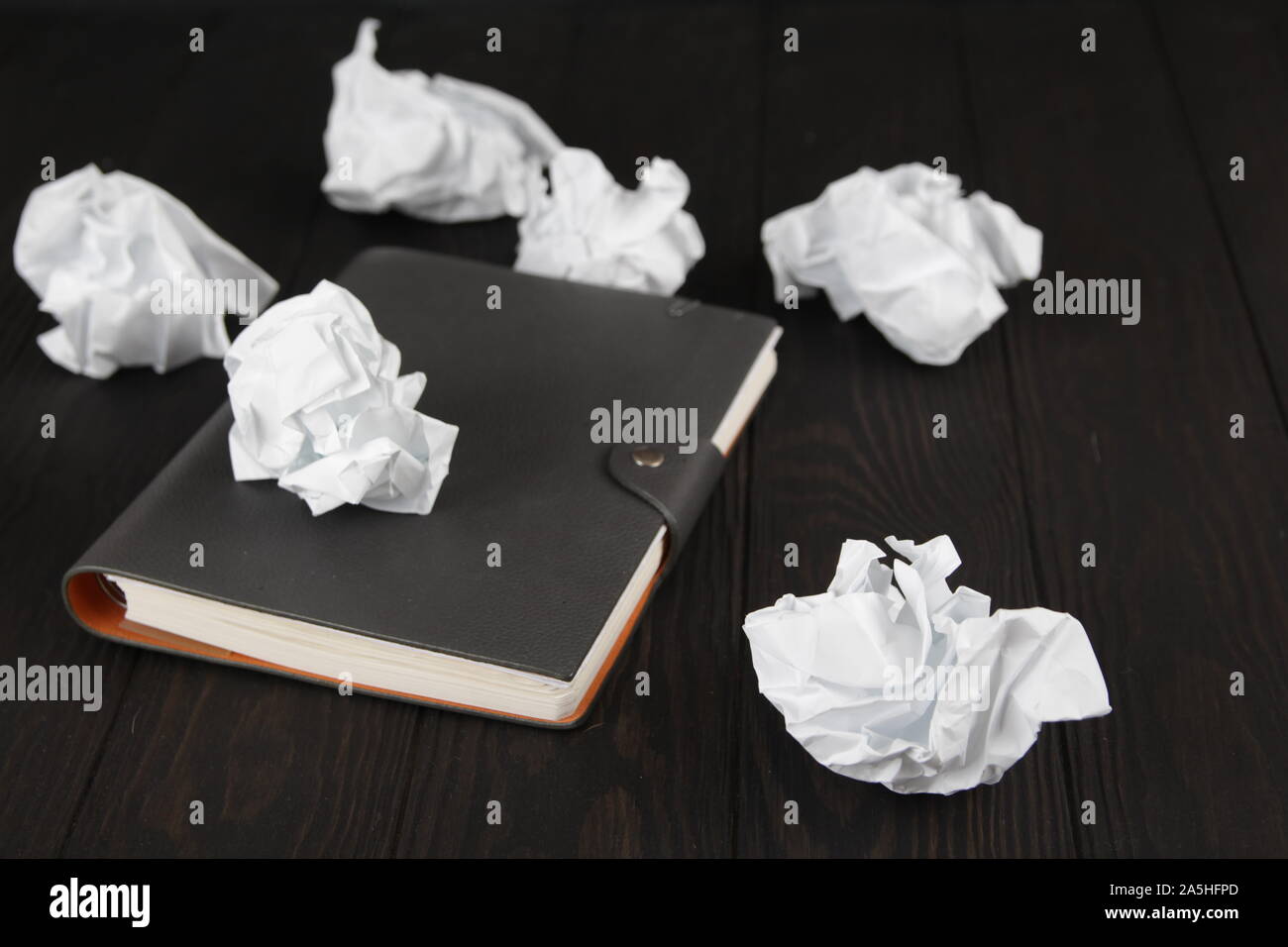 Empty notebook and crumpled paper balls on grey table, flat lay. Space. For text. Stock Photo