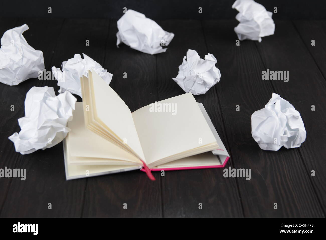 Empty notebook and crumpled paper balls on grey table, flat lay. Space. For text. Stock Photo
