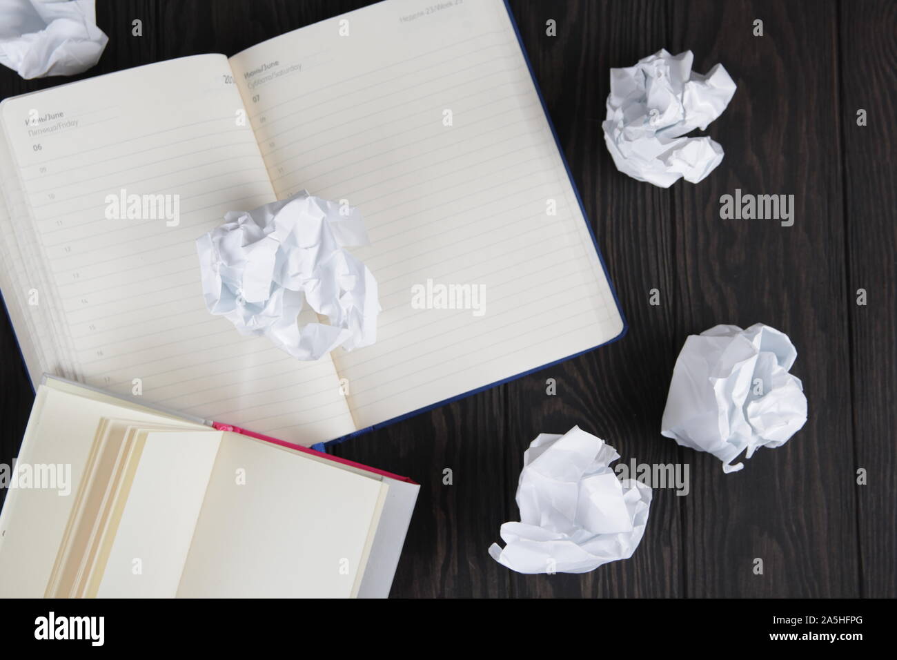 Empty notebook and crumpled paper balls on grey table, flat lay. Space. For text. Stock Photo