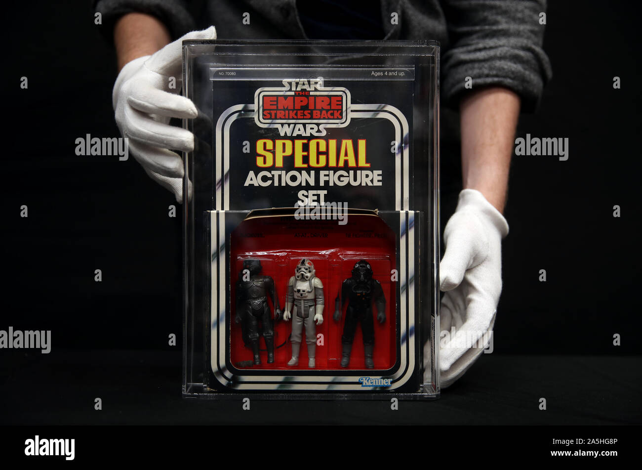 A Prop Store employee adjusts an Imperial Set ESB Series 3 3-pack of action figures from the film Star Wars: The Empire Strokes Back (estimate Â£3,000 - Â£5000), during a preview for the Prop Store's forthcoming cinema poster live auction. Stock Photo