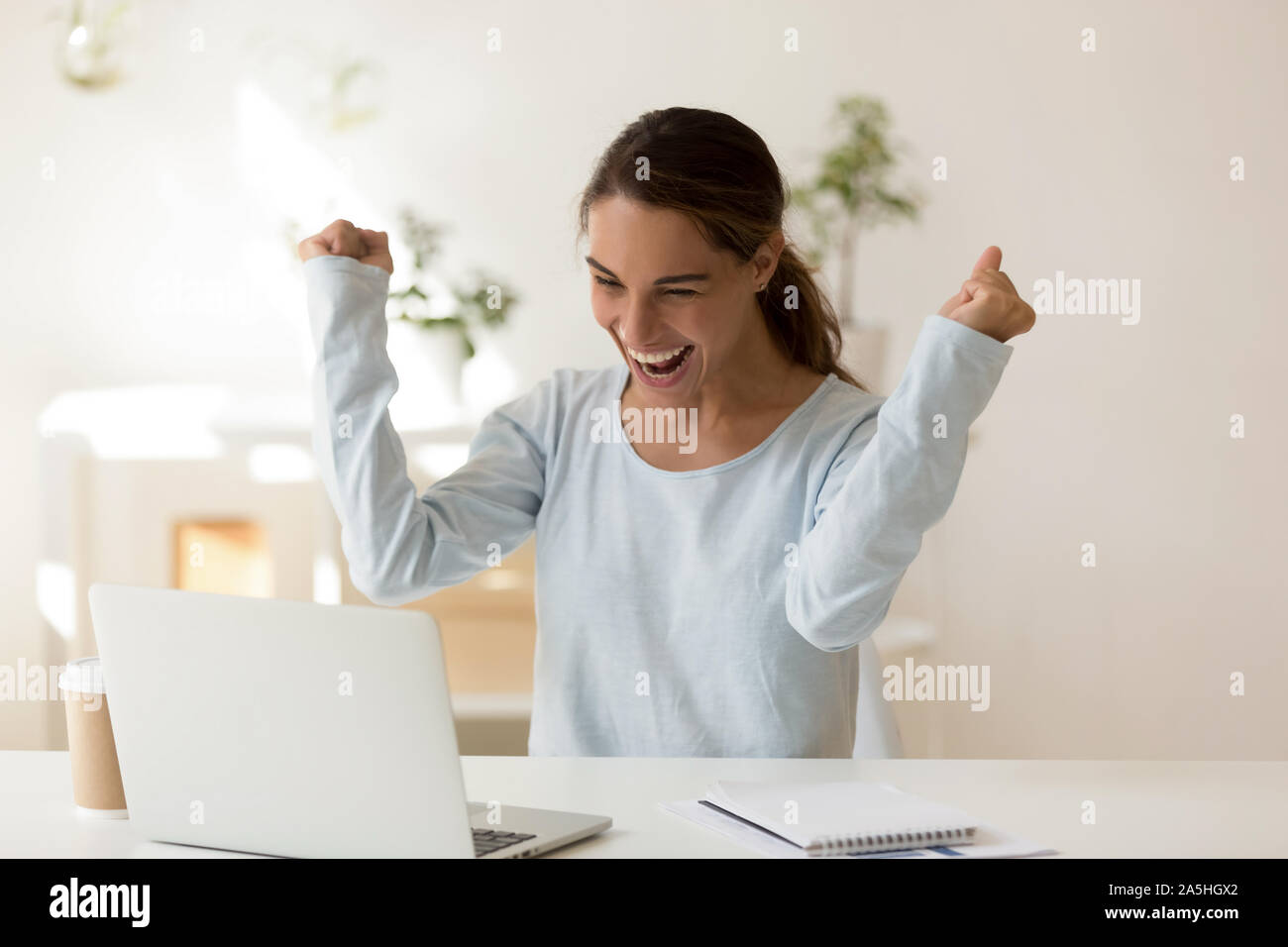 Euphoric laughing mixed race millennial female student making yes gesture. Stock Photo