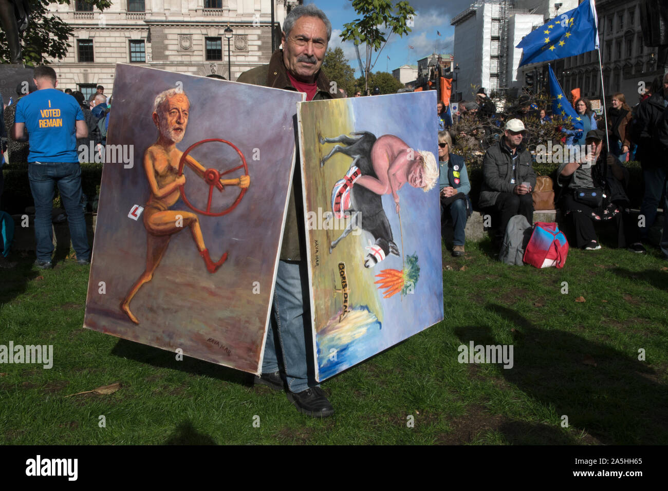 Kaya Mar Turkish artist political cartoonist with his paintings of Jeremy Corbyn and Boris Johnson. 2019 London UK. Rally in Parliament Square for Peoples Vote Campaign. 2010s UK HOMER SYKES Stock Photo