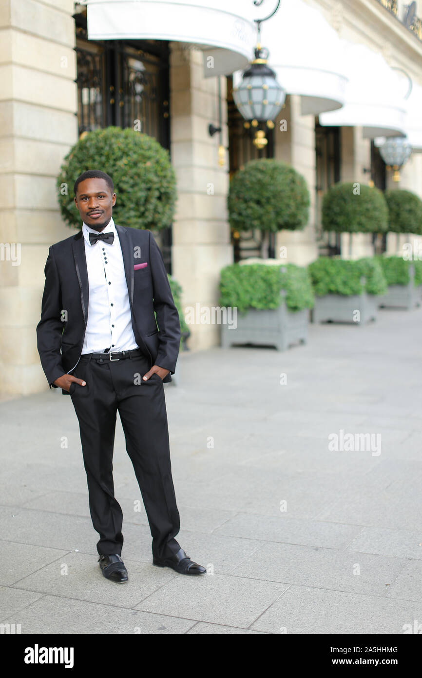Afro american successful man wearing suit and standing near building ...