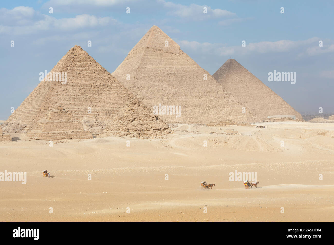 Egypt, Giza, the great Pyramids at Giza with horse drawn carts in the distance. Stock Photo