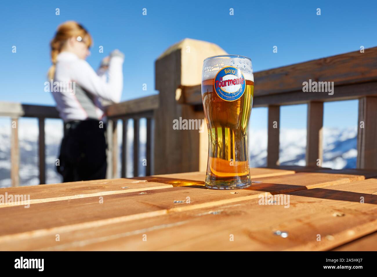 Having a beer on a terrace with scenic view, winter in the mountains Stock Photo