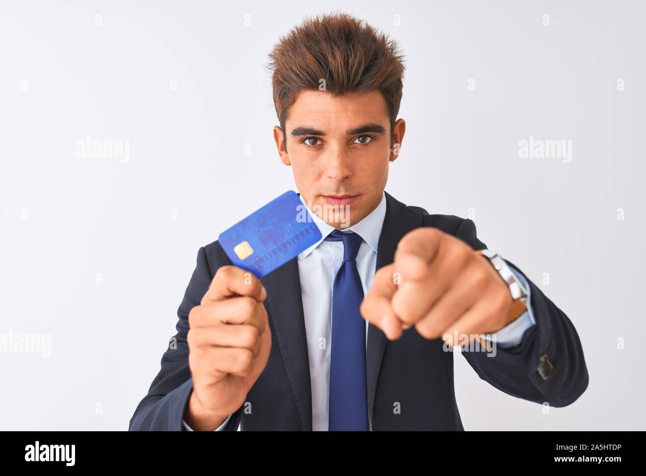 Young handsome businessman wearing suit holding credit card over ...