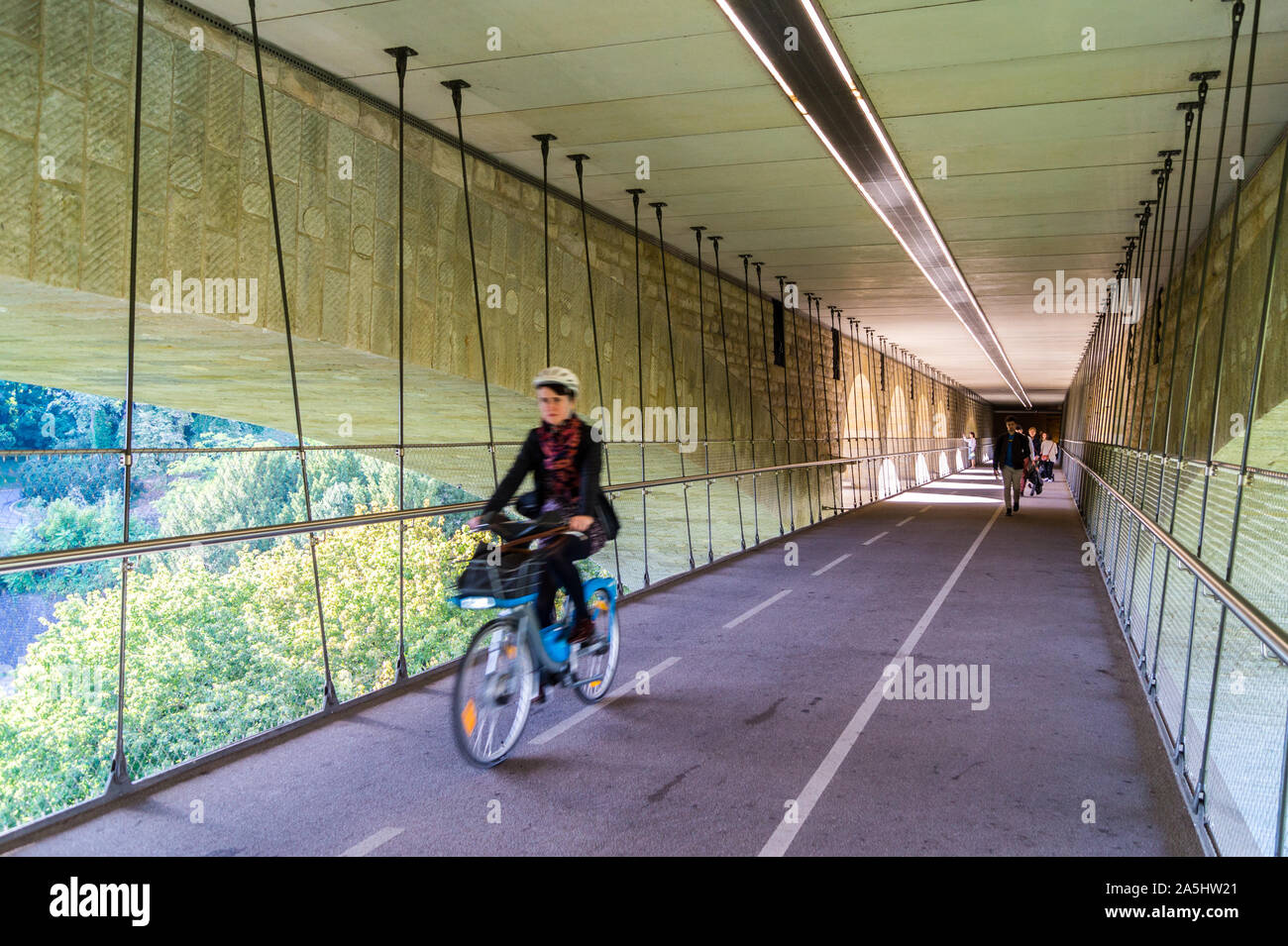 A female cyclist on the cycle path suspended under Pont Adolphe, Adolphe Bridge, Luxembourg city, Grand Duchy of Luxembourg Stock Photo