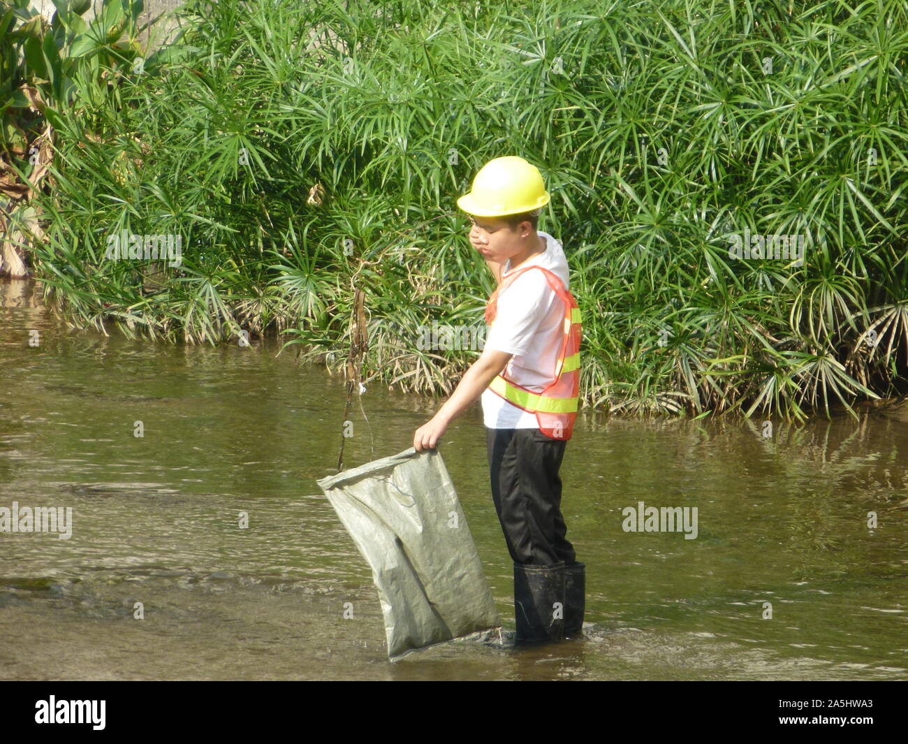 Sanitation workers clean up rubbish in rivers, in Xixiang River ...