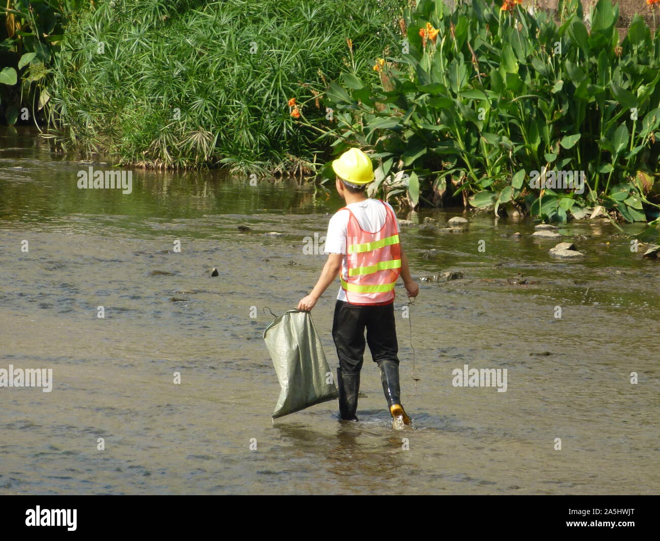 Sanitation workers clean up rubbish in rivers, in Xixiang River ...