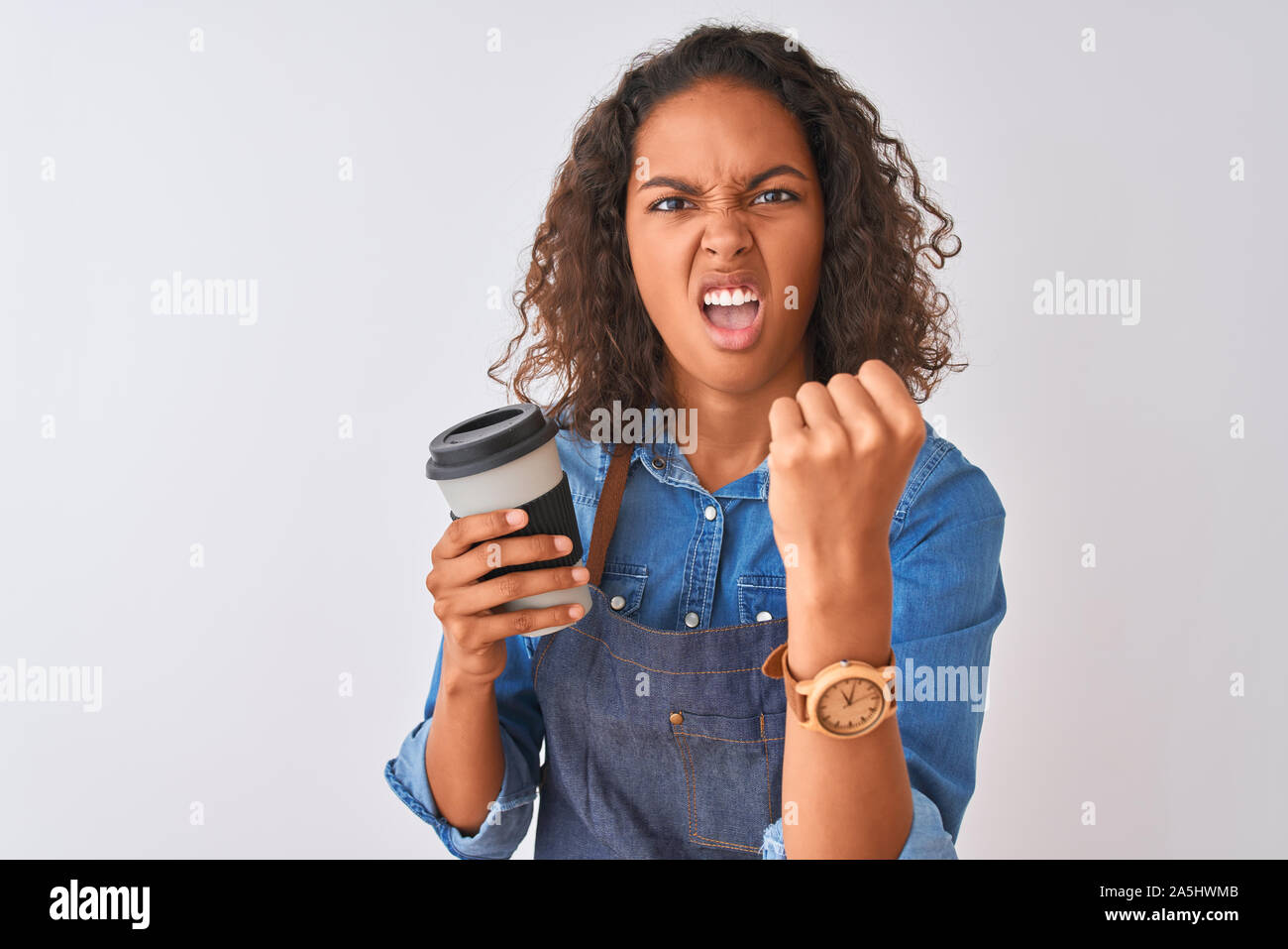 Young brazilian barista woman drinking take away coffee over isolated grey background annoyed and frustrated shouting with anger, crazy and yelling wi Stock Photo