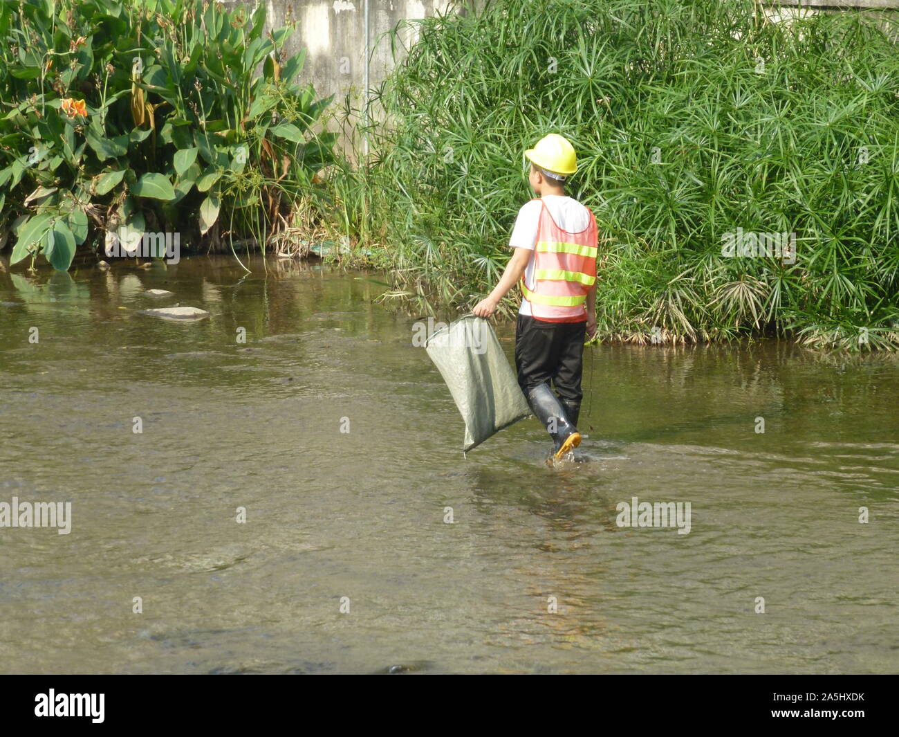 Sanitation workers clean up rubbish in rivers, in Xixiang River ...