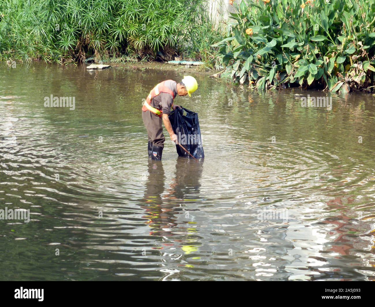 Sanitation workers clean up rubbish in rivers, in Xixiang River ...
