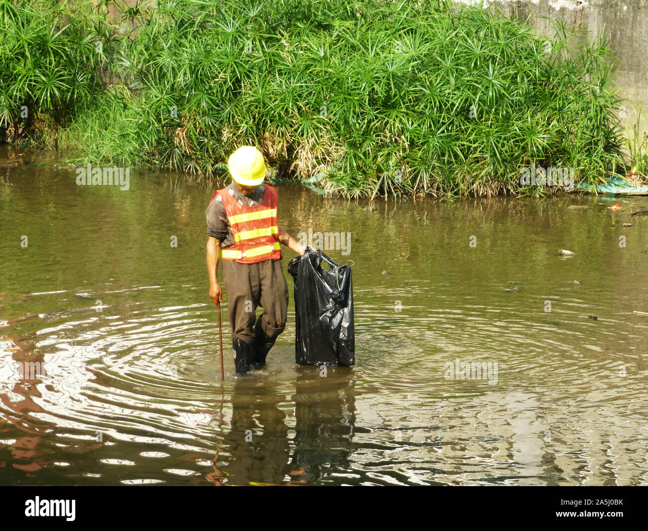 Sanitation workers clean up rubbish in rivers, in Xixiang River ...