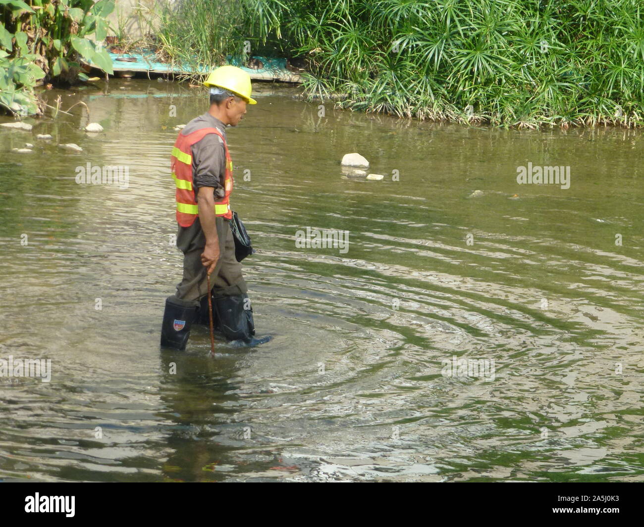 Sanitation workers clean up rubbish in rivers, in Xixiang River ...