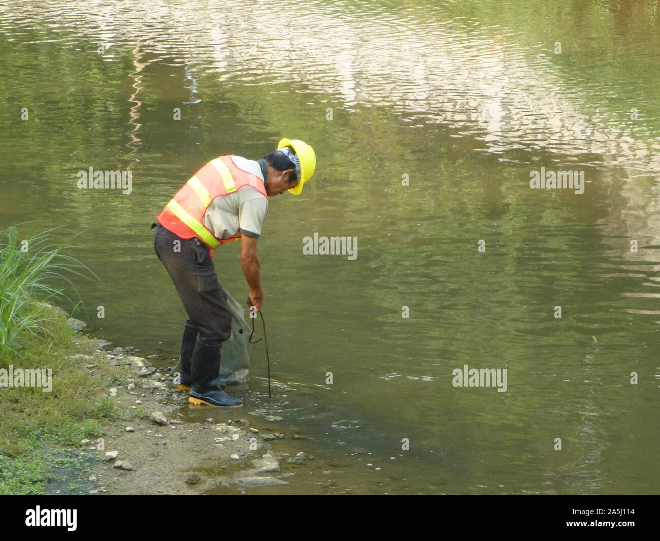 Sanitation workers clean up rubbish in rivers, in Xixiang River ...