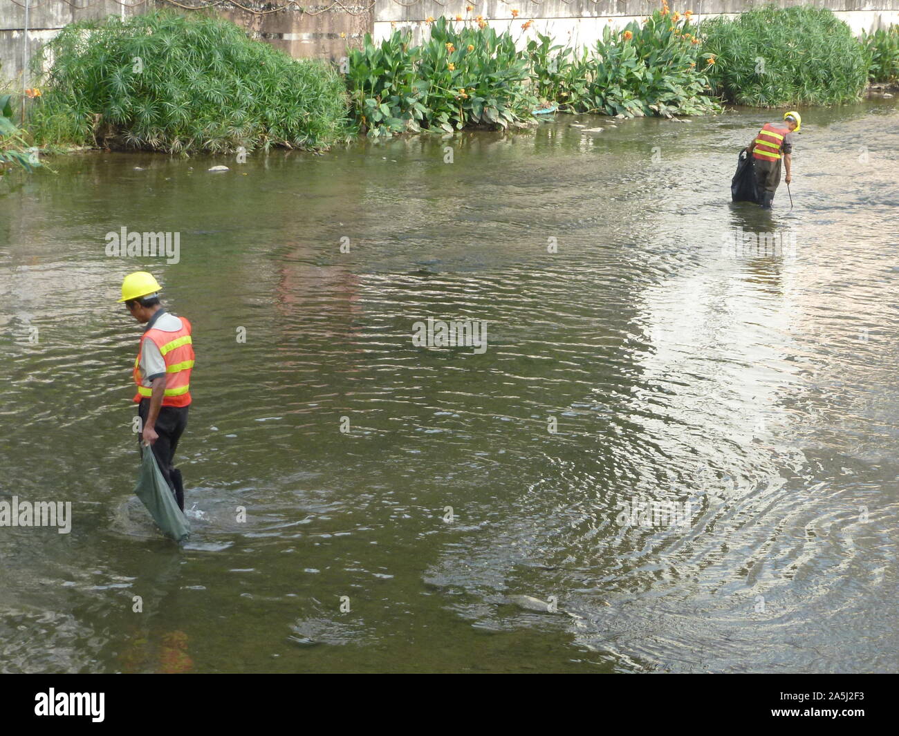 Sanitation workers clean up rubbish in rivers, in Xixiang River ...