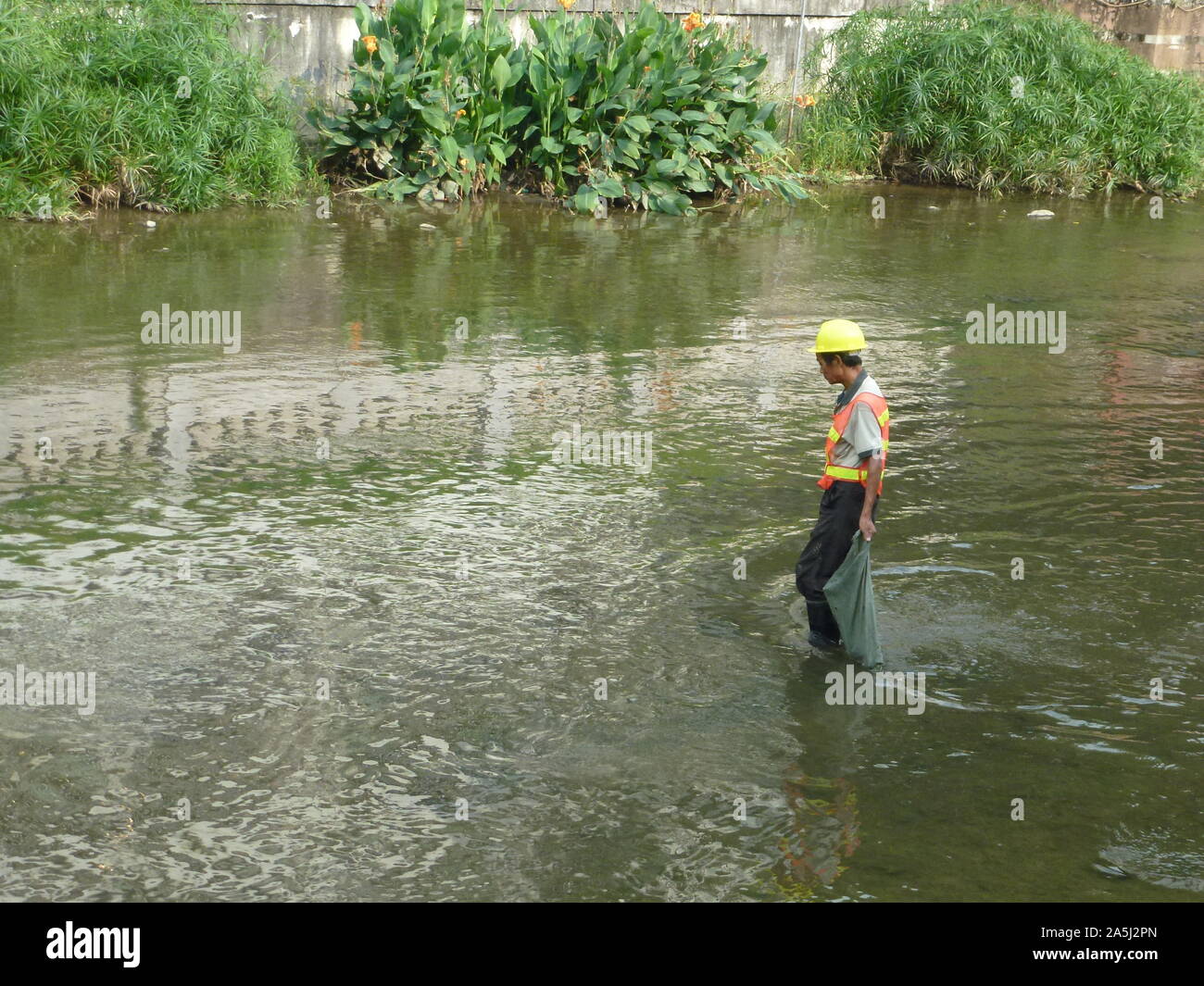 Sanitation workers clean up rubbish in rivers, in Xixiang River ...