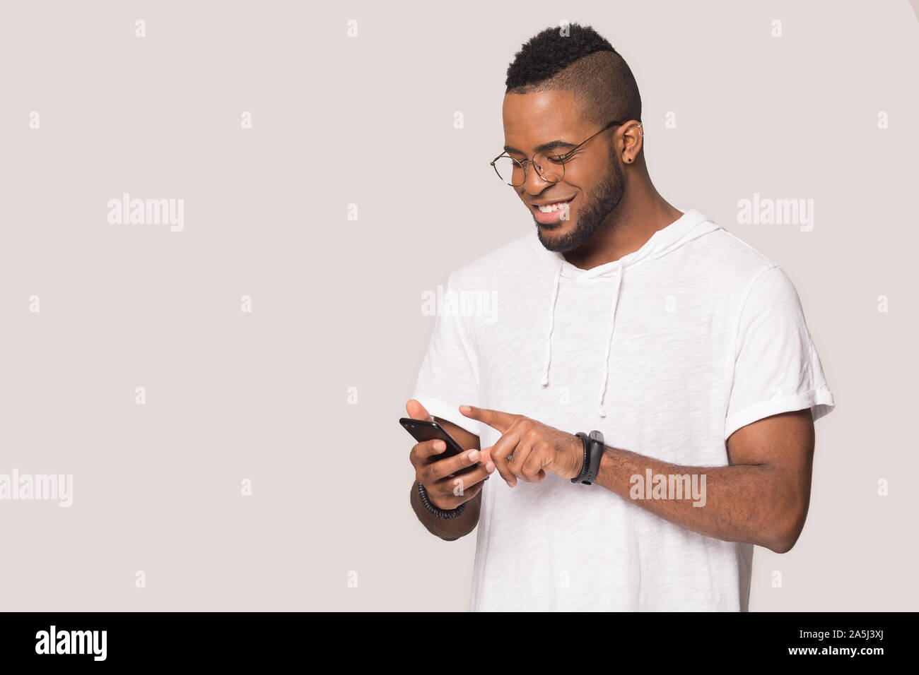 Smiling biracial man using modern cellphone with wireless internet Stock Photo