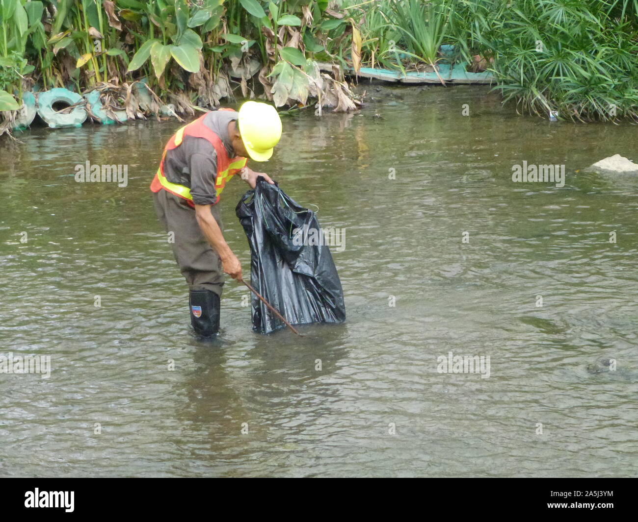 Sanitation workers clean up rubbish in rivers, in Xixiang River ...