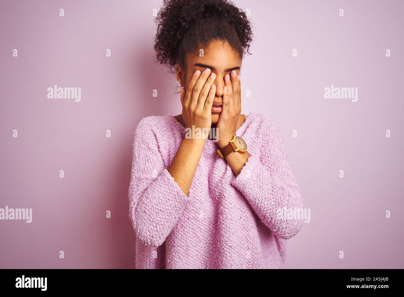 Young african american woman wearing winter sweater standing over isolated pink background rubbing eyes for fatigue and headache, sleepy and tired exp Stock Photo