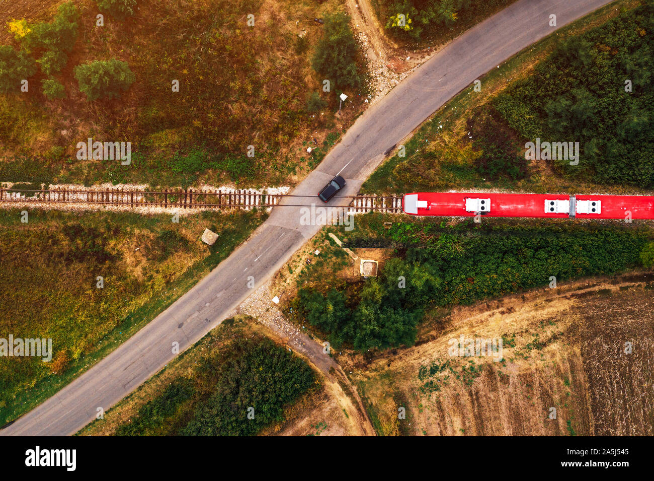 Aerial view of car and train on road and railway junction second before traffic accident Stock Photo