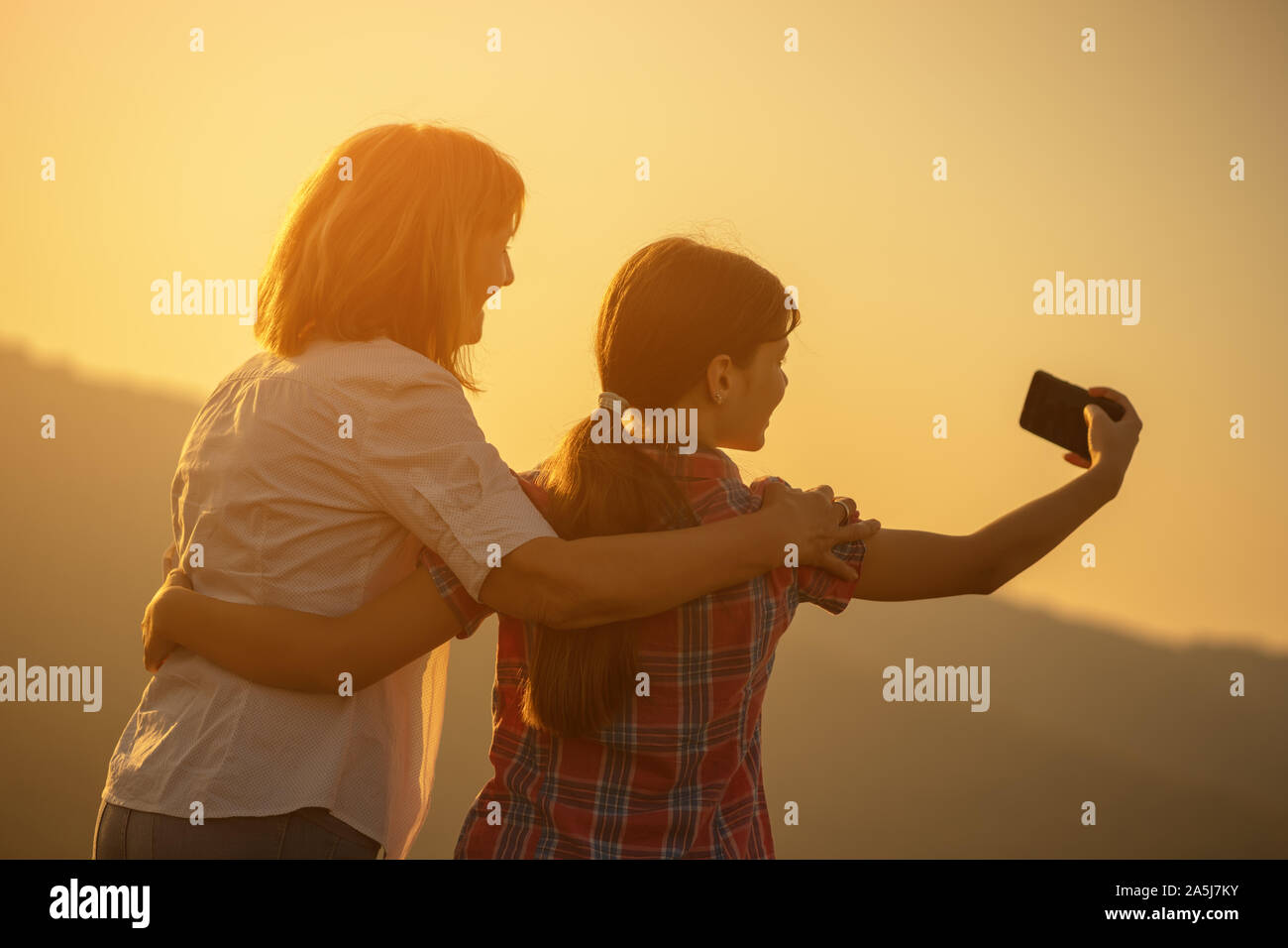 Happy grandmother and granddaughter enjoying nature and sunset Stock ...