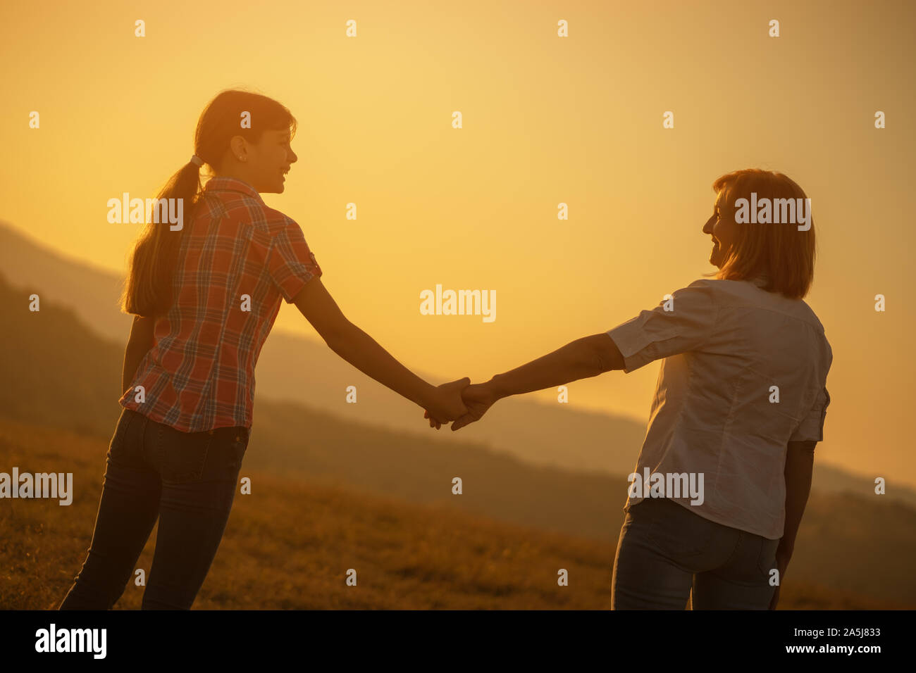 Happy grandmother and granddaughter enjoying sunset Stock Photo - Alamy