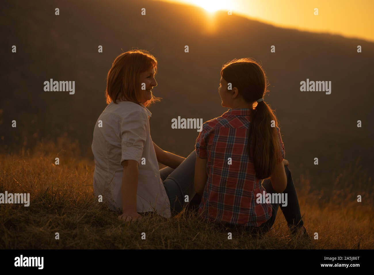 Happy grandmother and granddaughter enjoying nature and sunset Stock ...