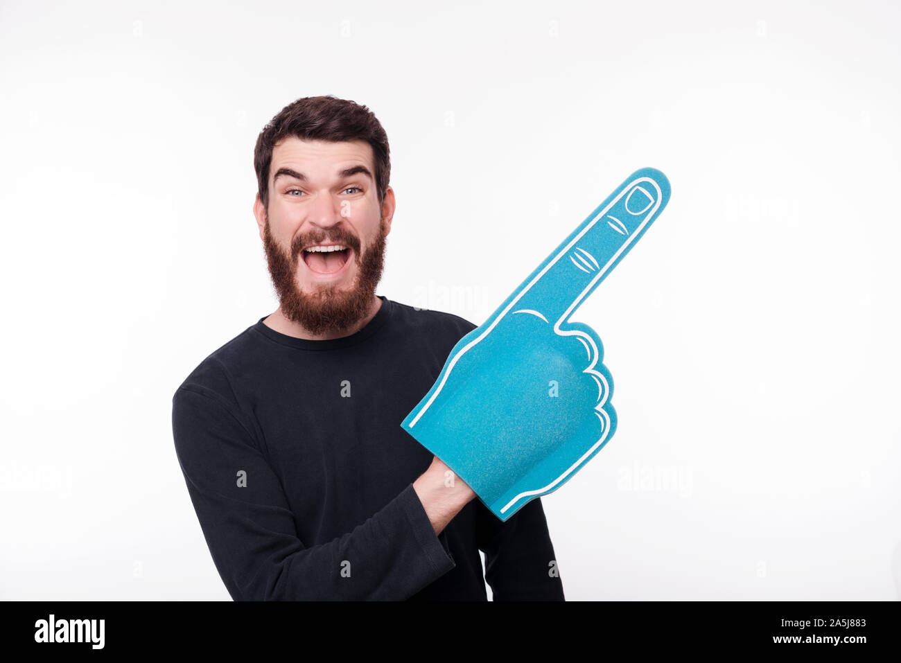 Portrait of young man pointing with fan finger foam at copyspace Stock Photo