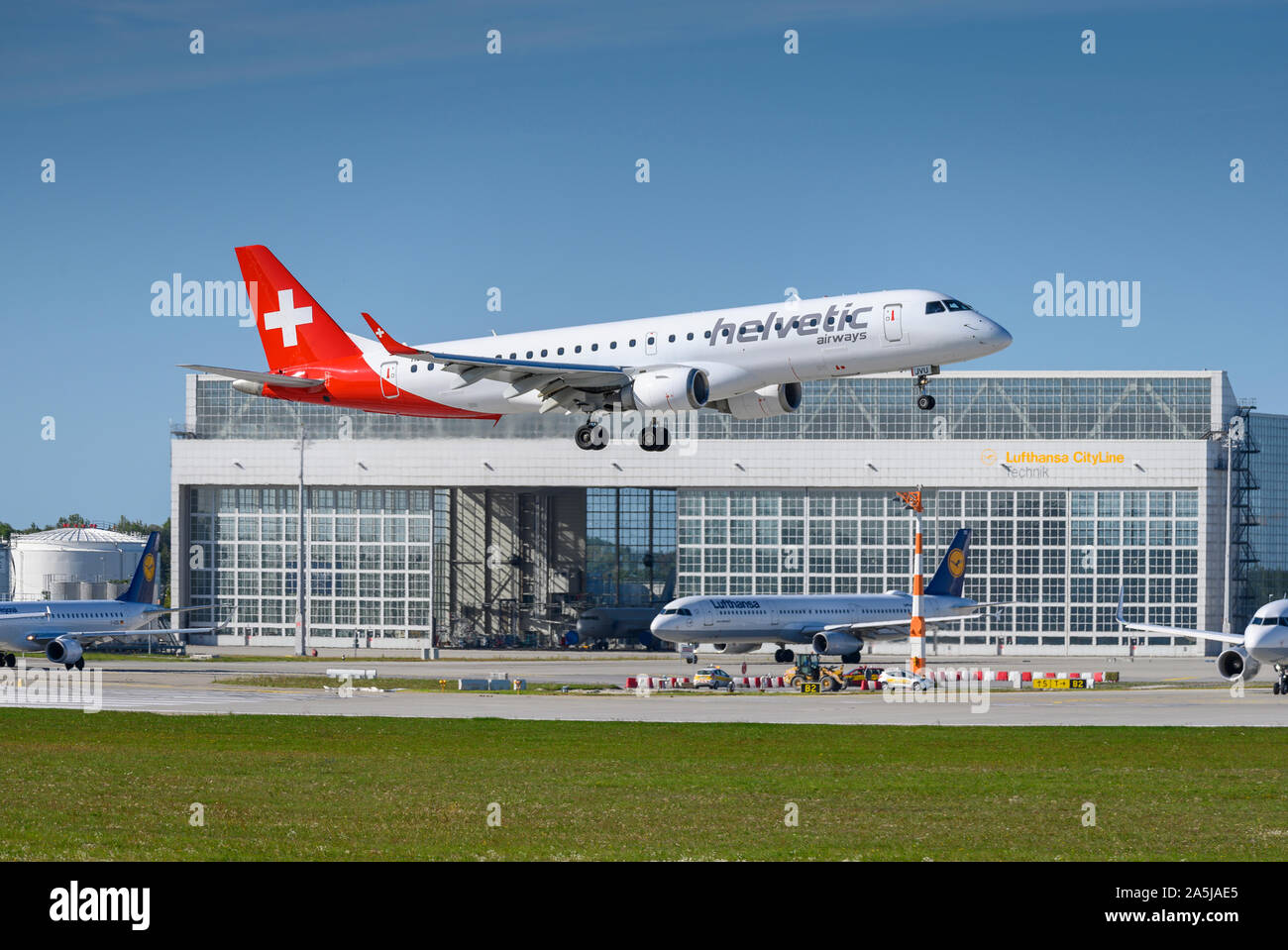 Munich, Germany - September 18. 2019 : Helvetic Airways Embraer ERJ-190 with the aircraft registration HB-JVU  approaching to the southern runway 08R Stock Photo