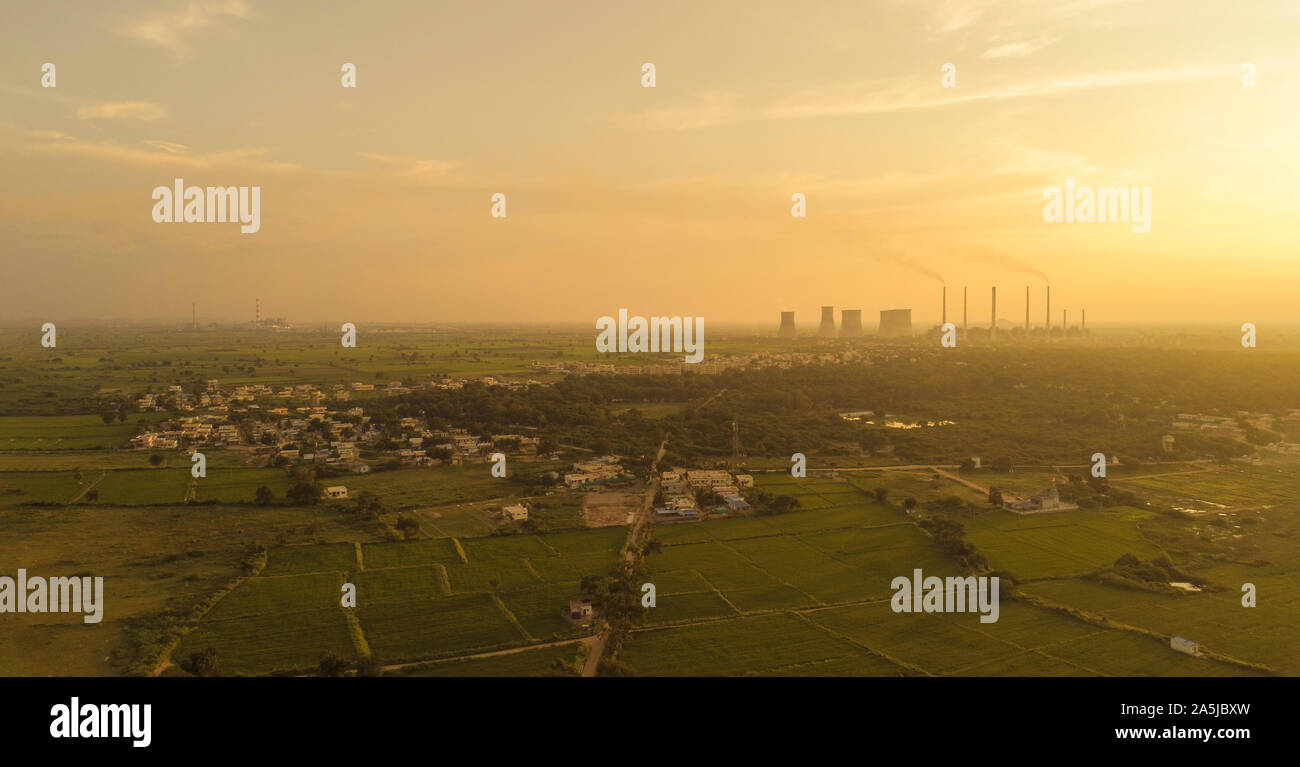 Aerial view of coal power plant - Sunrise near green agriculture field with factories outside the city, Raichur, India Stock Photo