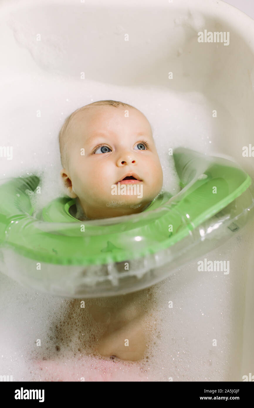 The baby is newborn, the girl is bathing in the bathroom with a