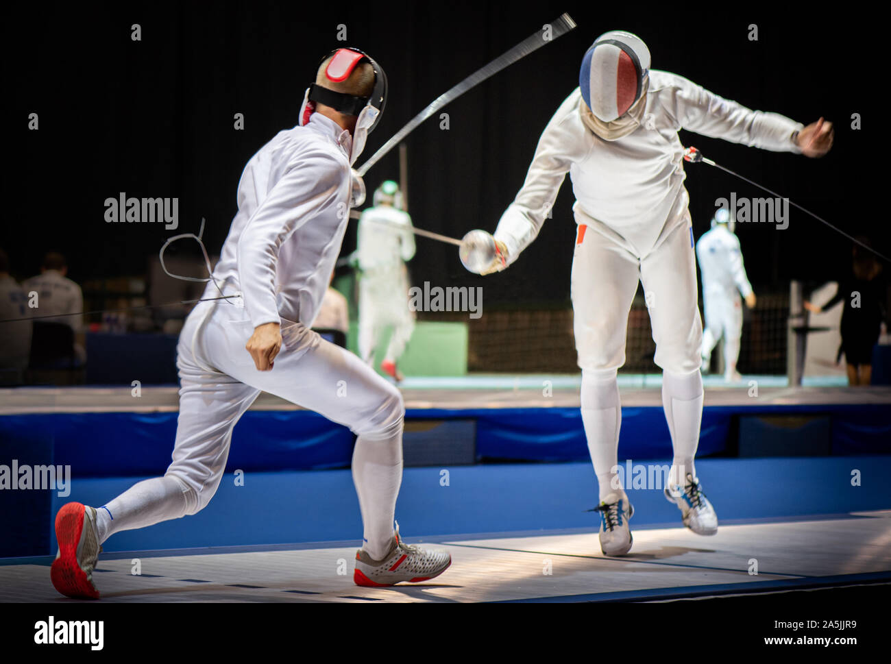 Two fencing athletes fight on professional sports arena Stock Photo Alamy