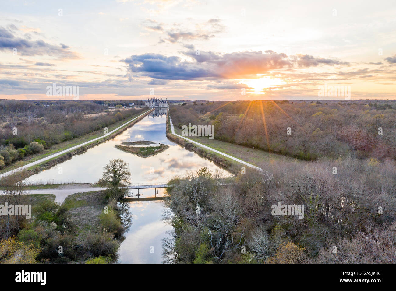 France, Loir et Cher, Loire Valley listed as World Heritage by UNESCO, Chambord, royal castle, the canalized Cosson river at sunset (aerial view) // F Stock Photo