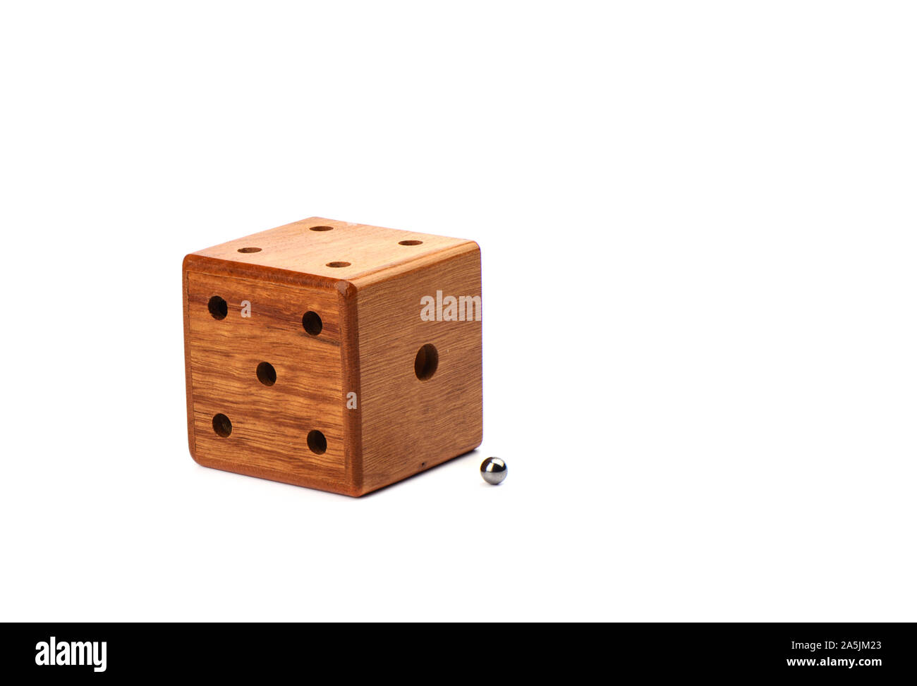 Puzzle magic cube three-dimensional maze. Wooden cube with a metal ball on a white background. Puzzle concept. Stock Photo
