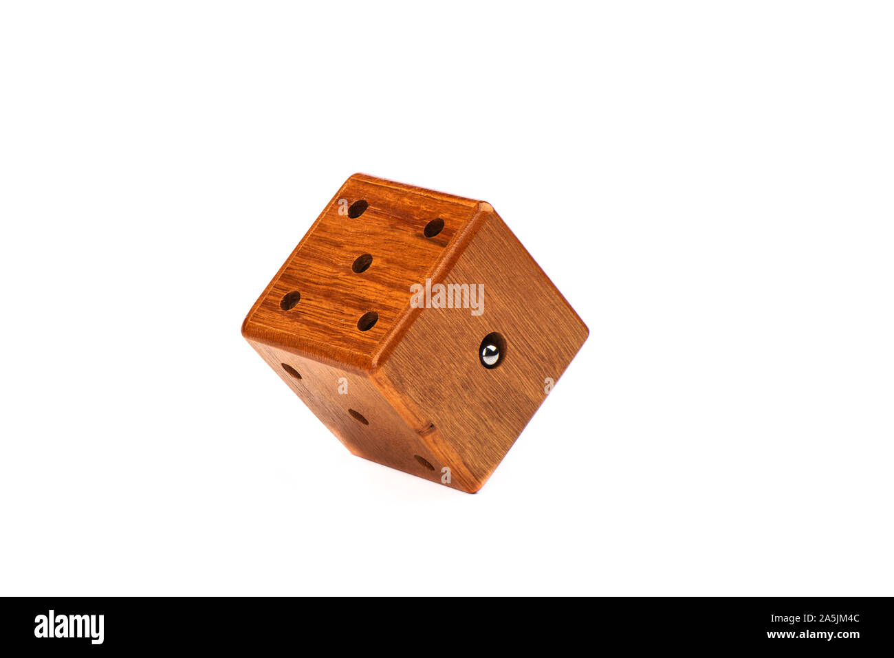 Puzzle magic cube three-dimensional maze. Wooden cube with a metal ball on a white background. Puzzle concept. Copy space. Stock Photo