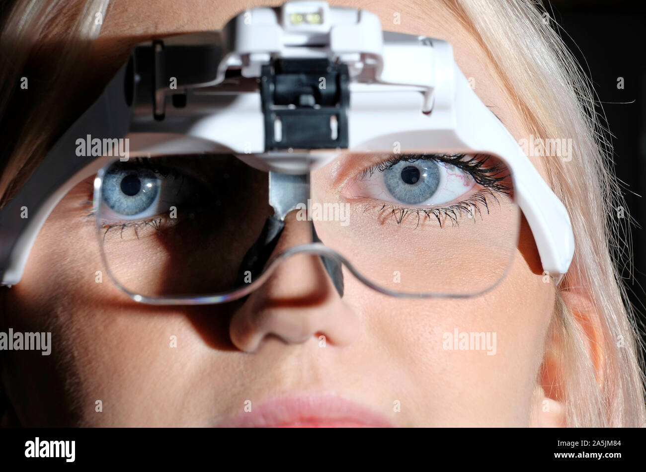 young female person using magnifying glasses headset Stock Photo