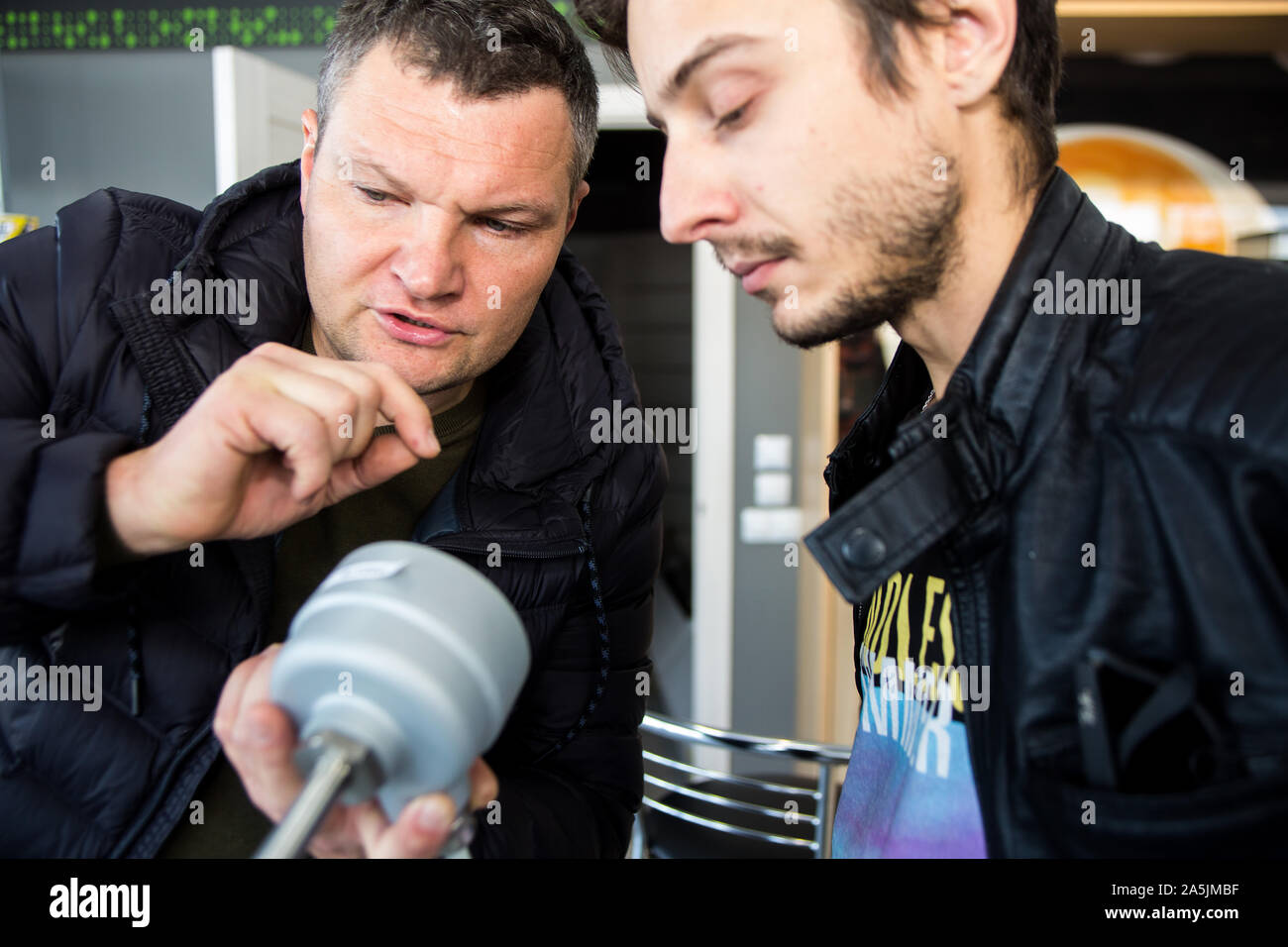 Ukrainian engineer installing remote electronic fuel gauging rode explaine's Petrol Stations retailing company IT expert know hows of measuring system Stock Photo