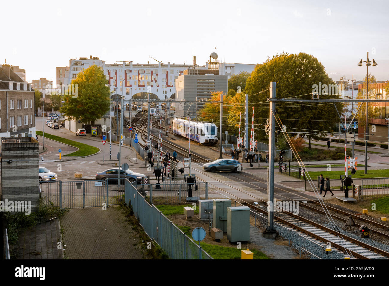 Cars and pedestrians crossing railway at Railway station, Heerlen, Limburg, Netherlands. Stock Photo